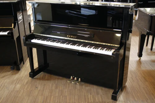 Schwarzes Kawai Klavier mit weißen und schwarzen Tasten steht auf Holzboden in einem hellen Musikgeschäft.​​​​​​​​​​​​​​​​​​​​​​​​​​​​​​​​​​​​​​​