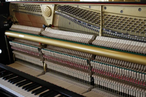 Detailaufnahme der Mechanik eines Kawai Klaviers mit Hämmern, Saiten und Tastatur in ruhiger Umgebung​​​​​​​​​​​​​​​​​​​​​​​​​​​​​​​​​​​​​​​​​​​​