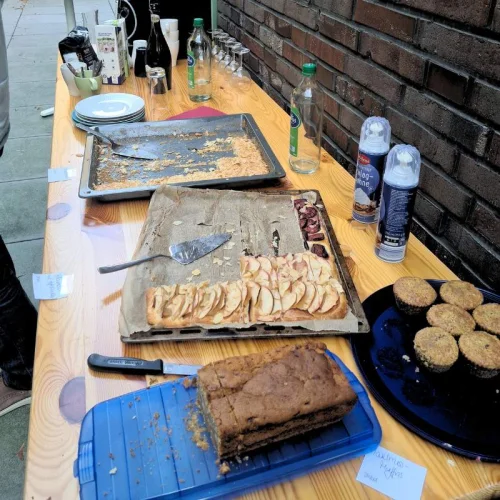 Kaffee-und-Kuchen-Buffet mit Kuchenblechen, Tellern, Gläsern und Getränkeflaschen beim Pädagogentreff