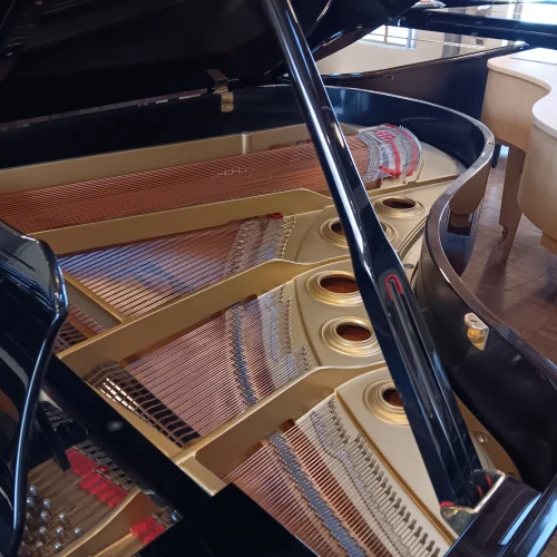 Detailaufnahme des geöffneten Yamaha Flügels C5 mit sichtbaren Saiten, Resonanzboden und schwarzem Gehäuse in hellem Raum.​​​​​​​​​​​​​​​​​​​​​​​