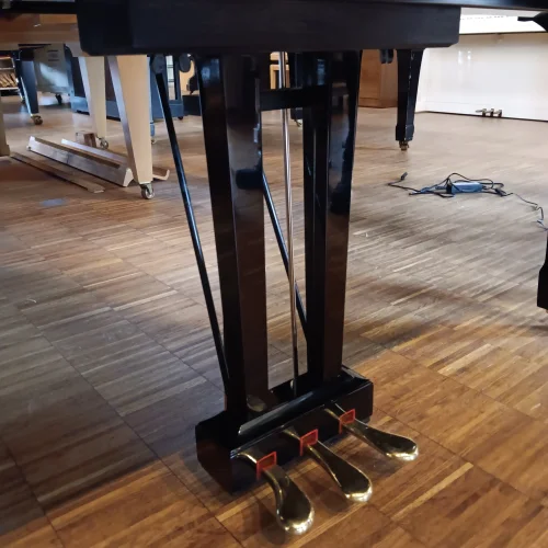 Nahaufnahme der Pedale eines Yamaha Flügels C5 auf Holzfußboden in einem Raum mit weiteren Klavieren​​​​​​​​​​​​​​​​​​​​​​​​​​​​​​​​​​​​​​​​​​​​​