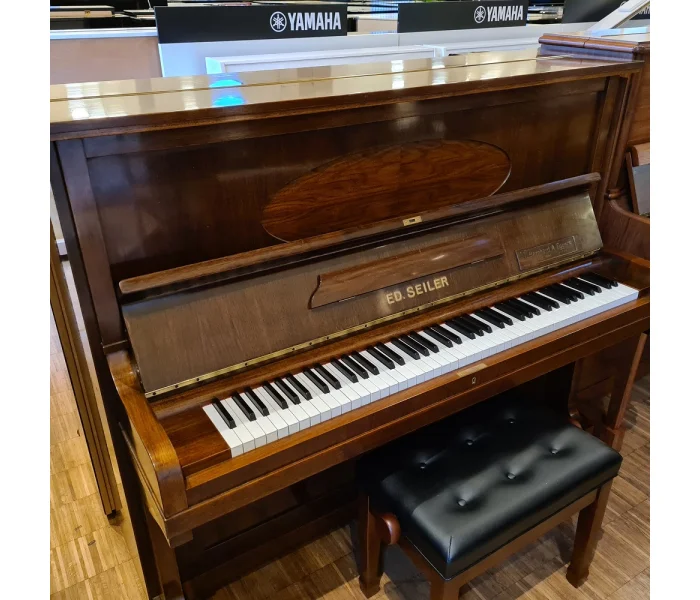Ed Seiler Klavier aus dunklem Holz mit weißen und schwarzen Tasten in einem Musikgeschäft mit Yamaha Instrumenten​​​​​​​​​​​​​​​​​​​​​​​​​​​​​​​​