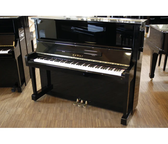 Schwarzes Kawai Klavier mit weißen und schwarzen Tasten steht auf Holzboden in einem hellen Musikgeschäft.​​​​​​​​​​​​​​​​​​​​​​​​​​​​​​​​​​​​​​​