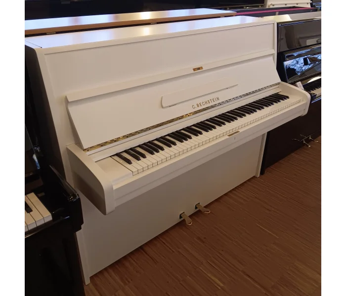 C. Bechstein Klavier 12 N in Schwarz, Frontansicht mit Klaviatur, Notenpult und drei Pedalen.