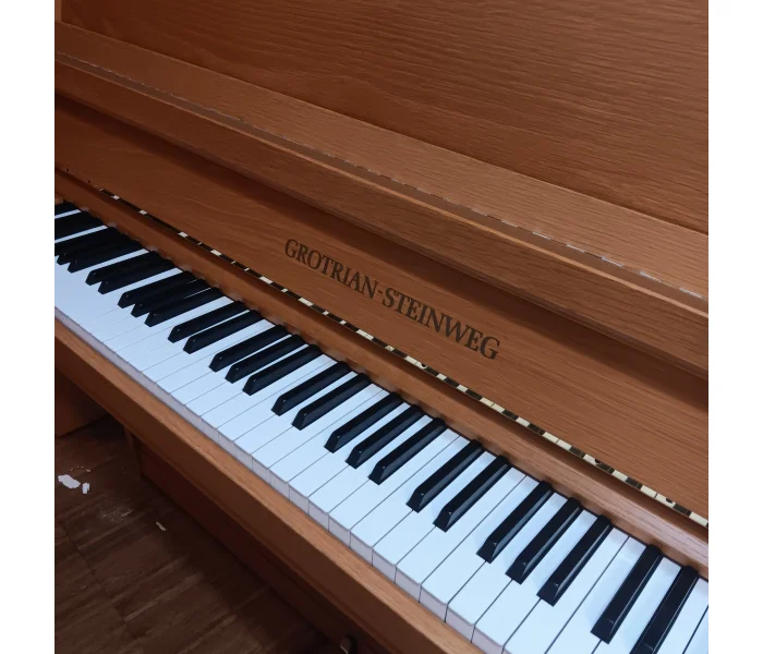 Nahaufnahme eines Grotrian-Steinweg Klaviers aus Eichenholz mit sichtbarer Klaviatur und Holzstruktur