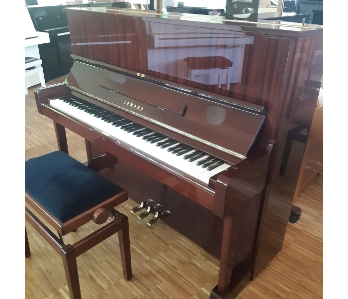 Yamaha Klavier U1 in Mahagoni – Frontansicht mit Klaviatur, Notenpult und Pedalen.